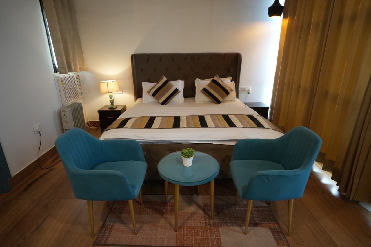 Private Family Villa — teal velvet armchairs, king bed and warm lighting